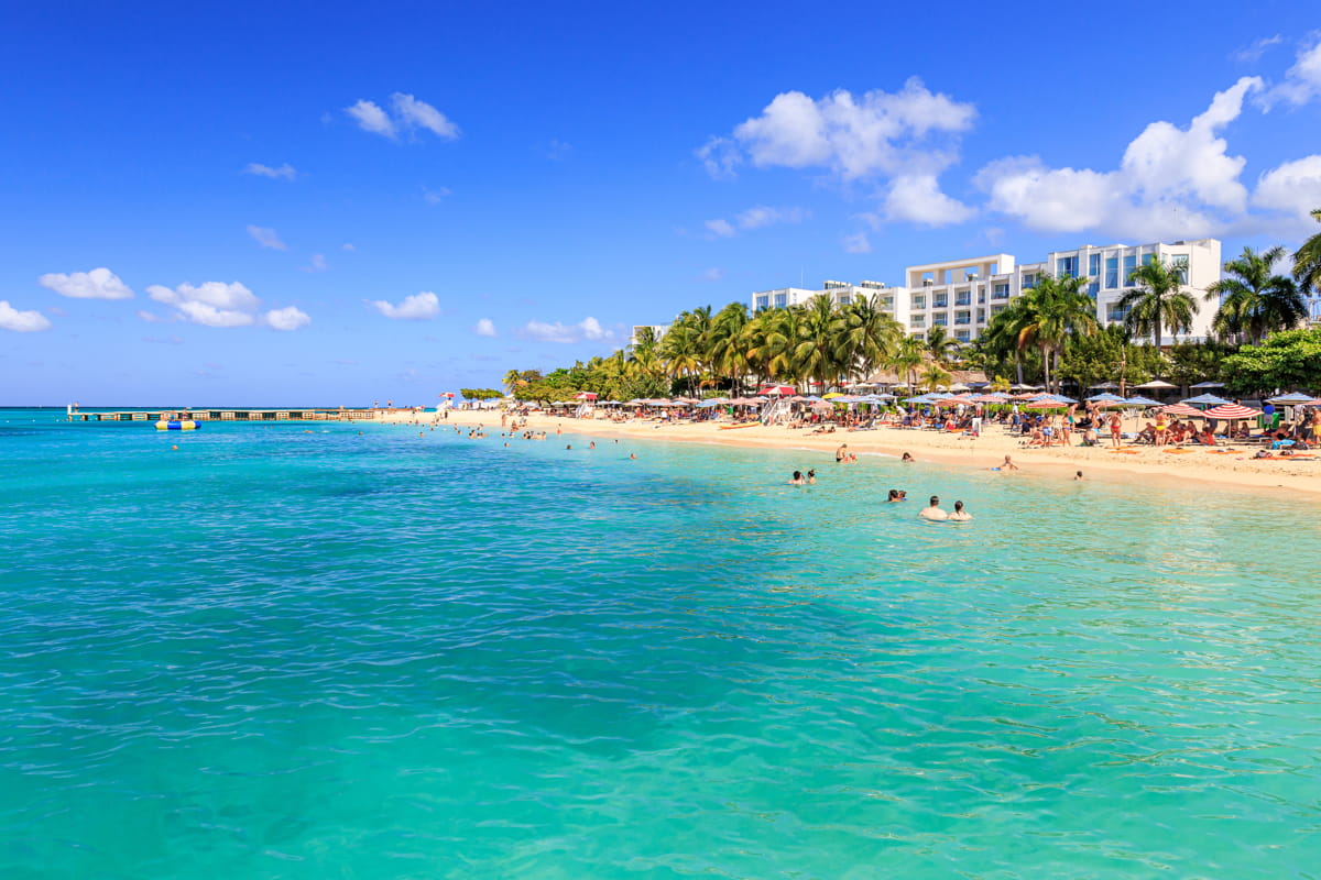 A scenic view of Montego Bay, Jamaica, featuring crystal-clear waters and palm-lined beaches