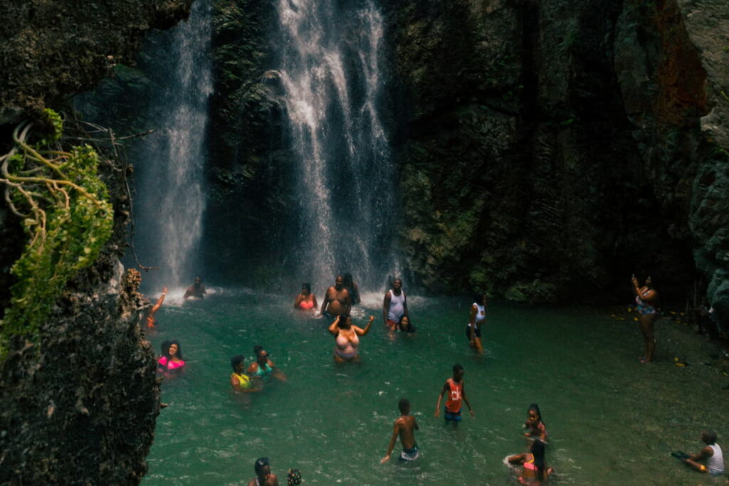 People enjoying a day at a waterfall during a public holiday in Jamaica.