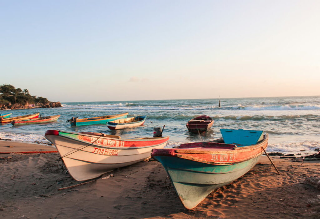 Fishing boats lined up on the sandy shores of Treasure Beach.